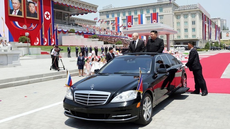 平壌での歓迎式典で高級車に乗るロシアのプーチン大統領と北朝鮮の金正恩総書記/Gavriil Grigorov/Pool/AFP/Sputnik/Getty Images